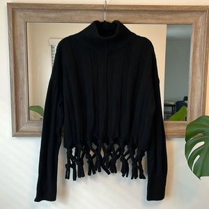 Black turtleneck sweater with tie detail at the bottom. Size M. Lightly worn.